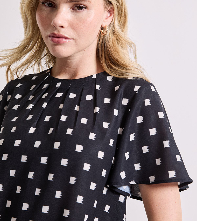 توب بكشكشة حول الرقبة وأكمام واسعة بطبعة